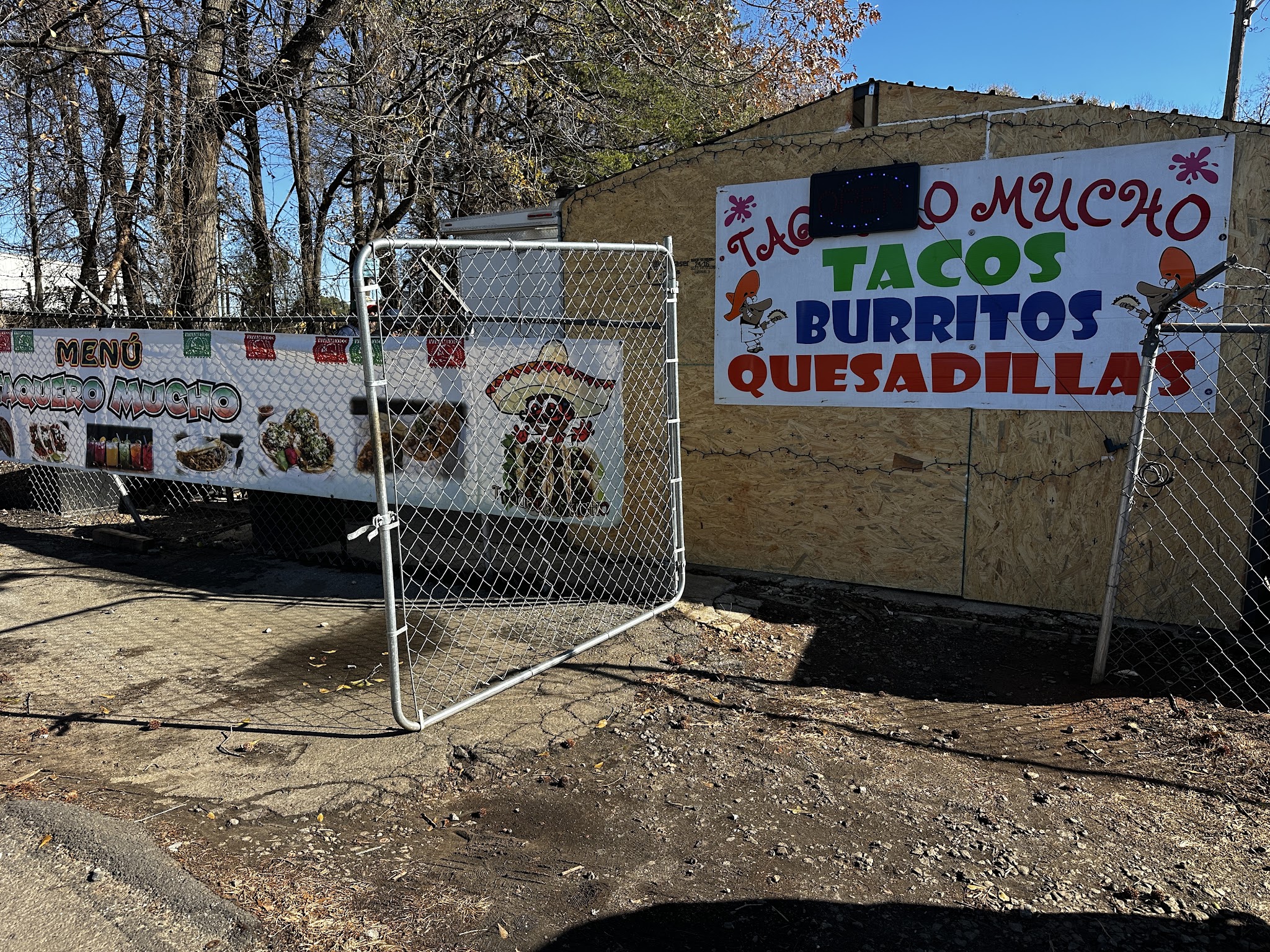 Hand-painted Taquero Mucho sign reading tacos, burritos, quesadillas next to a menu banner
